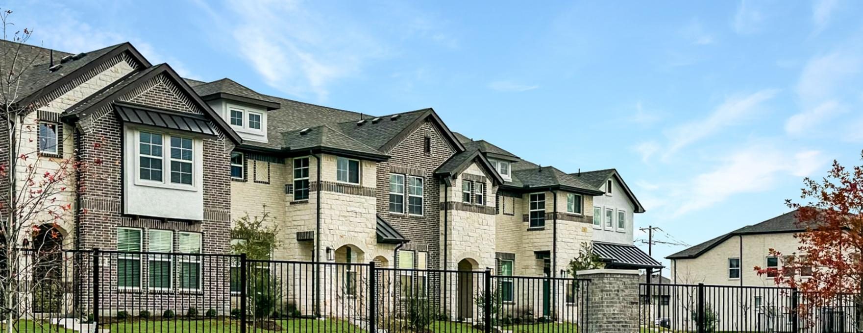 a large townhouse with a fence and grass at The Villas at Bardin