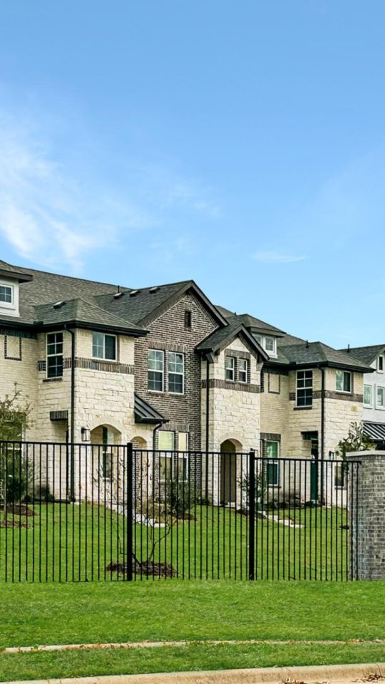 a large townhouse with a fence and grass at The Villas at Bardin