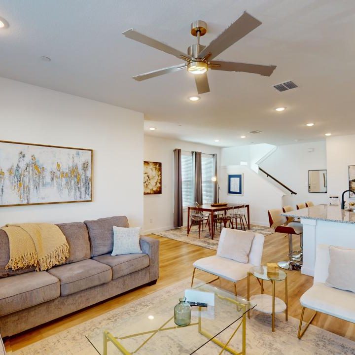 a living room with a ceiling fan and a couch at The Villas at Bardin